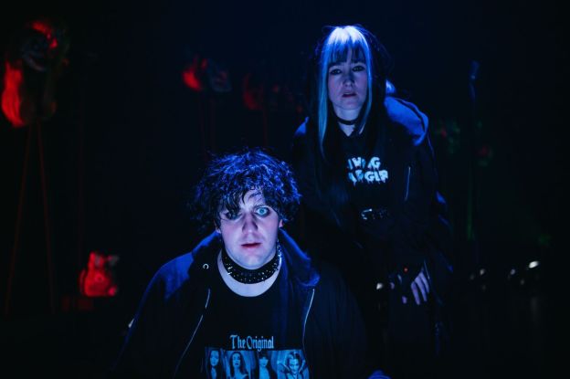 Two actors portraying youth in goth clothing, one male one female.